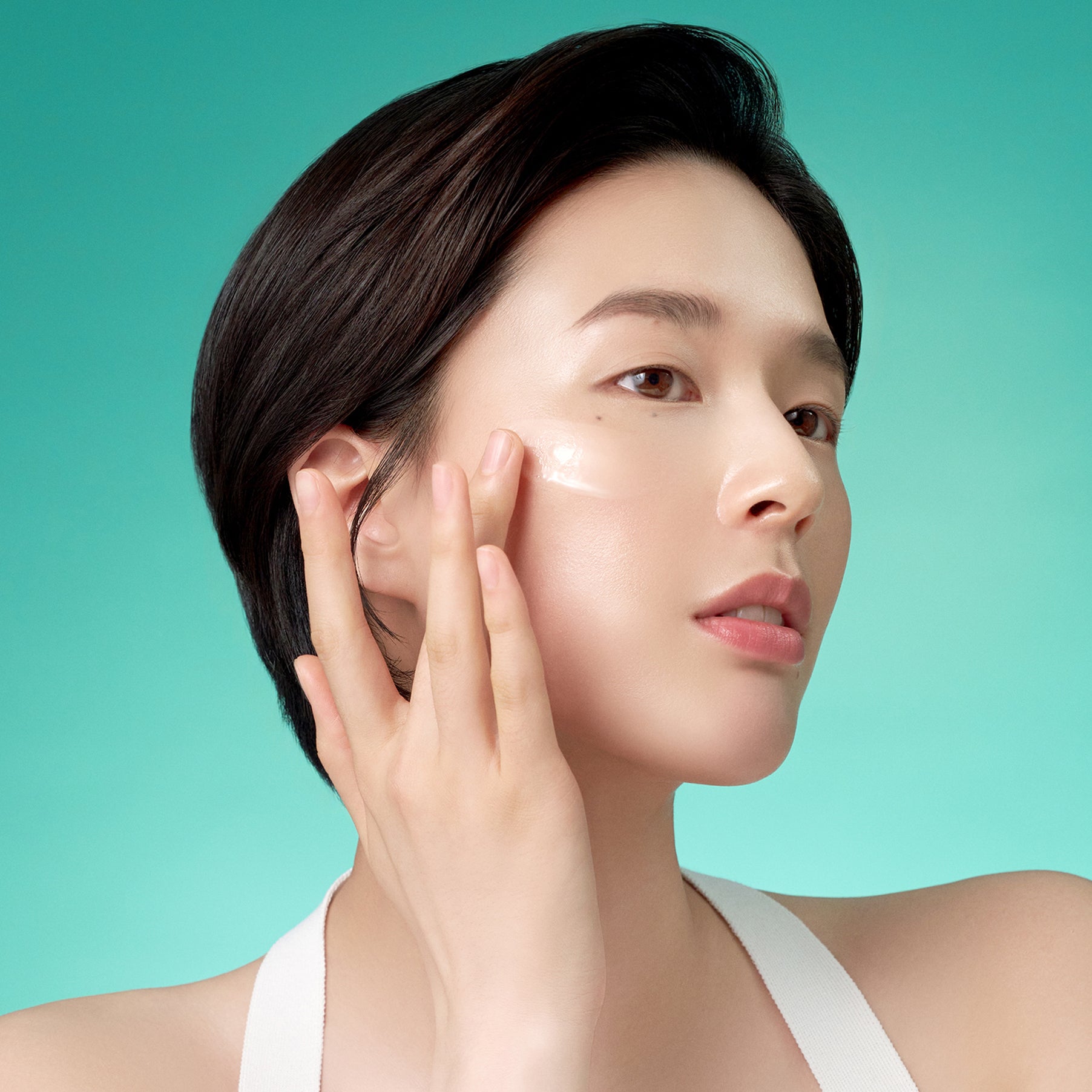 Décris l'image en français : PURITO Mighty Bamboo Panthenol Serum 30ml de PURITO, visage appliquant un soin, fond turquoise.