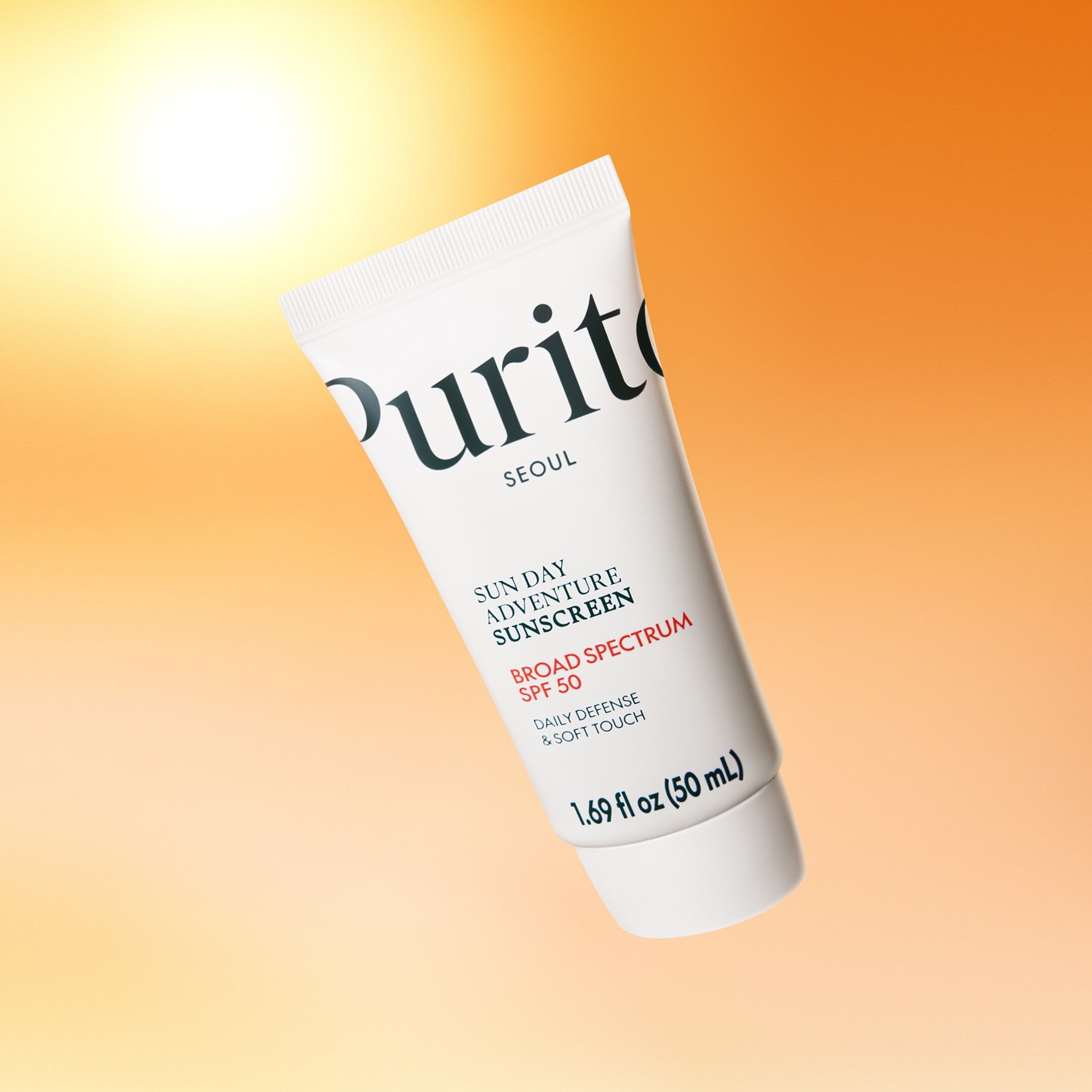 Décrivez l’image : PURITO Sunday Adventure Sunscreen SPF50 50ml, tube PURITO sur fond orange ensoleillé.