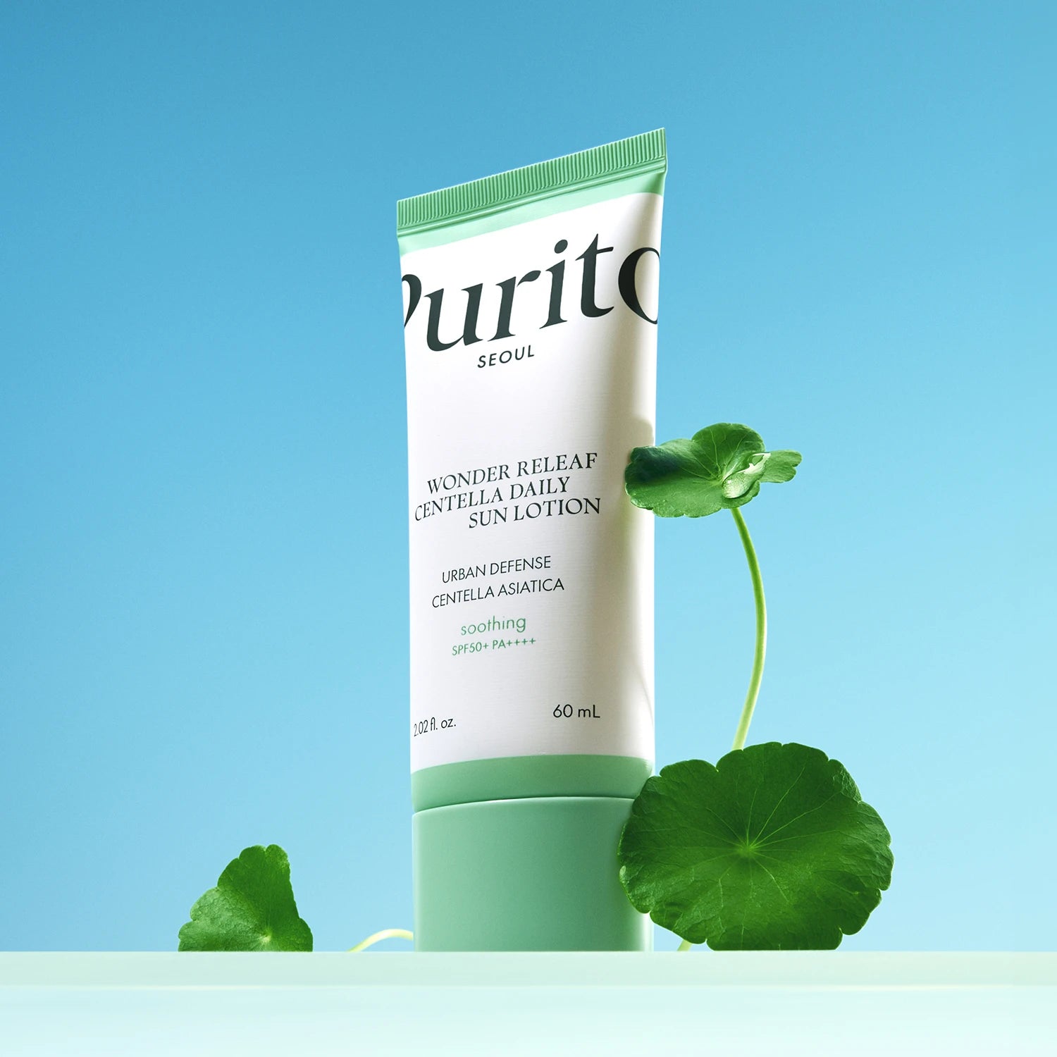PURITO Wonder Releaf Centella Daily Sun Lotion SPF50+PA++++ de Purito sur fond bleu, avec fleurs de centella en visuel