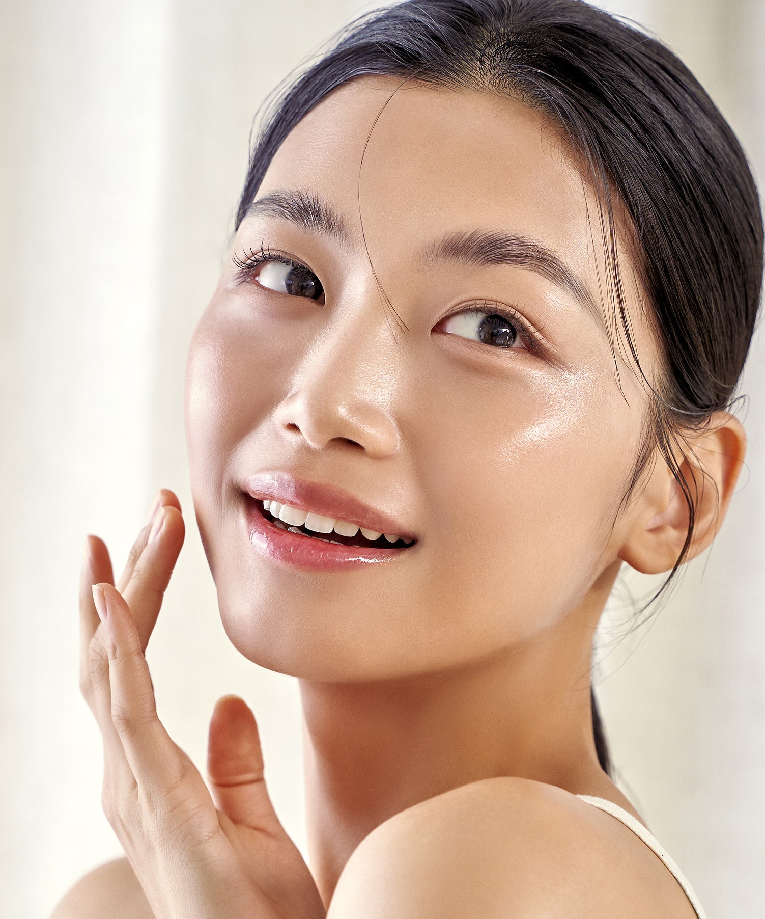 Décris en français : visage radieux utilisant PURITO Wonder Releaf Centella Daily Sun Lotion SPF50+PA++++, marque PURITO, contexte soin visage