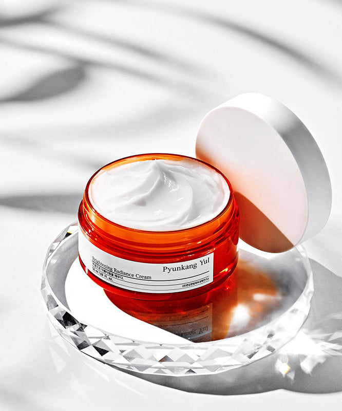 Crème PYUNKANG YUL Brightening Radiance 50ml en pot ouvert sur fond blanc élégant.