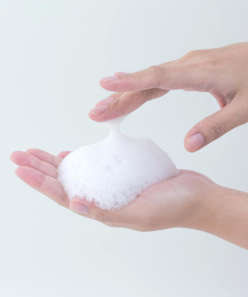 Mousse de PYUNKANG YUL Calming Acne Clear Body Wash 290ml dans des mains pour une peau apaisée et nette.