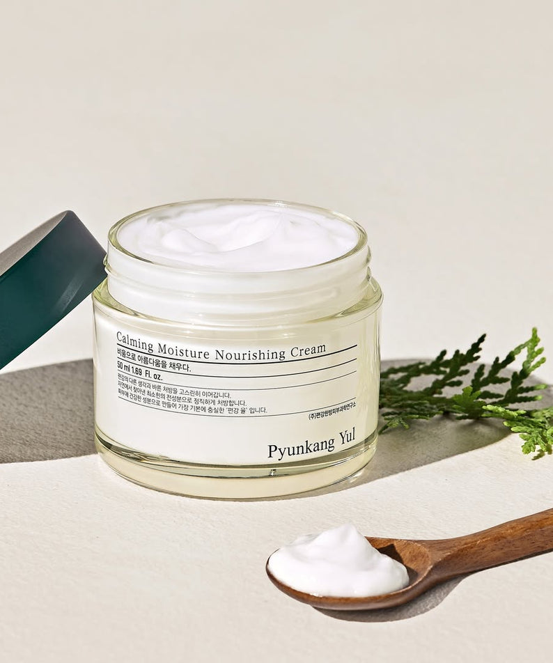 Crème nourrissante PYUNKANG YUL Calming Moisture Nourishing Cream 50ml avec texture onctueuse, vue de côté avec cuillère en bois.