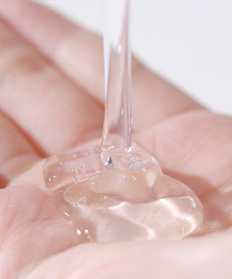 Texture du PYUNKANG YUL Low pH Scalp Shampoo 500ml versé dans une main, liquide clair et apaisant pour le cuir chevelu.