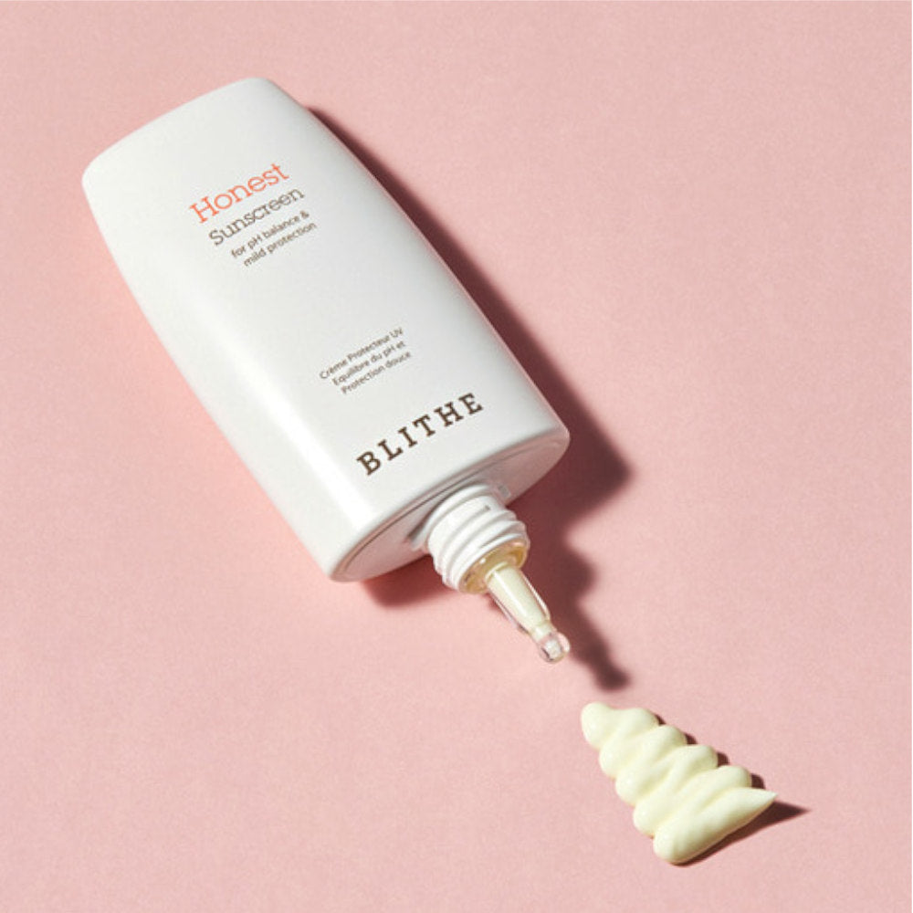 Décris l'image en français : BLITHE Honest Sunscreen 50ml, tube crème solaire de la marque BLITHE sur fond rose.