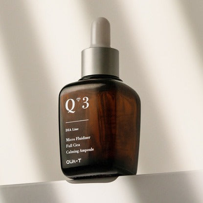 QUA-T Dia Nano Emulsion Full Cica Soothing Ampoule 30ml QUA-T, flacon ambre sur fond clair, contexte beauté skincare