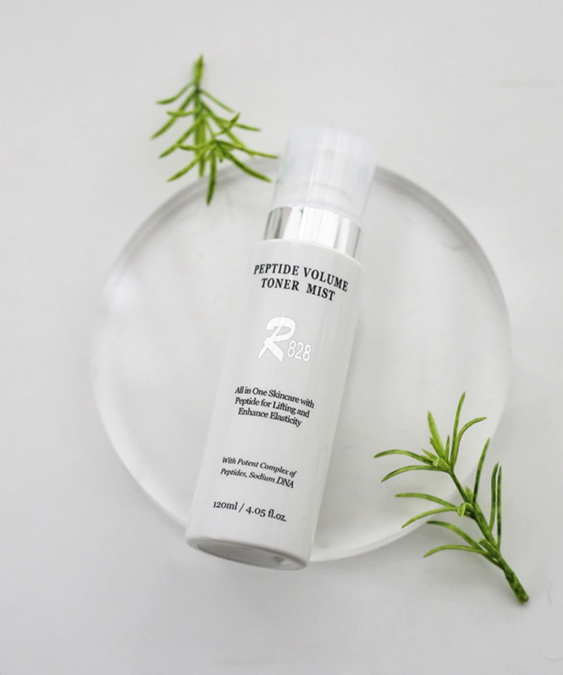 Flacon de R828 Peptide Volume Toner Mist avec feuillage, soin hydratant et raffermissant pour la peau.