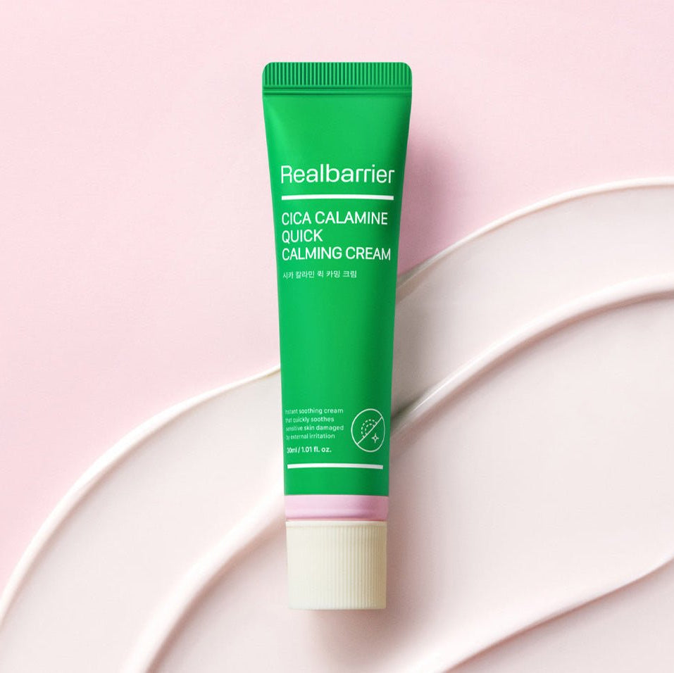 REAL BARRIER Cica Calamine Quick Calming Cream 30ml de Realbarrier, tube vert sur fond rose avec crème blanche.
