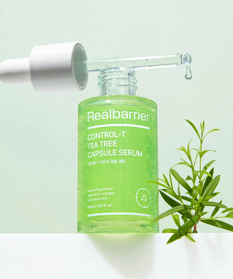 REAL BARRIER Control-T Tea Tree Capsule Serum 30ml, marque Realbarrier, flacon vert avec plantes de tea tree sur fond clair