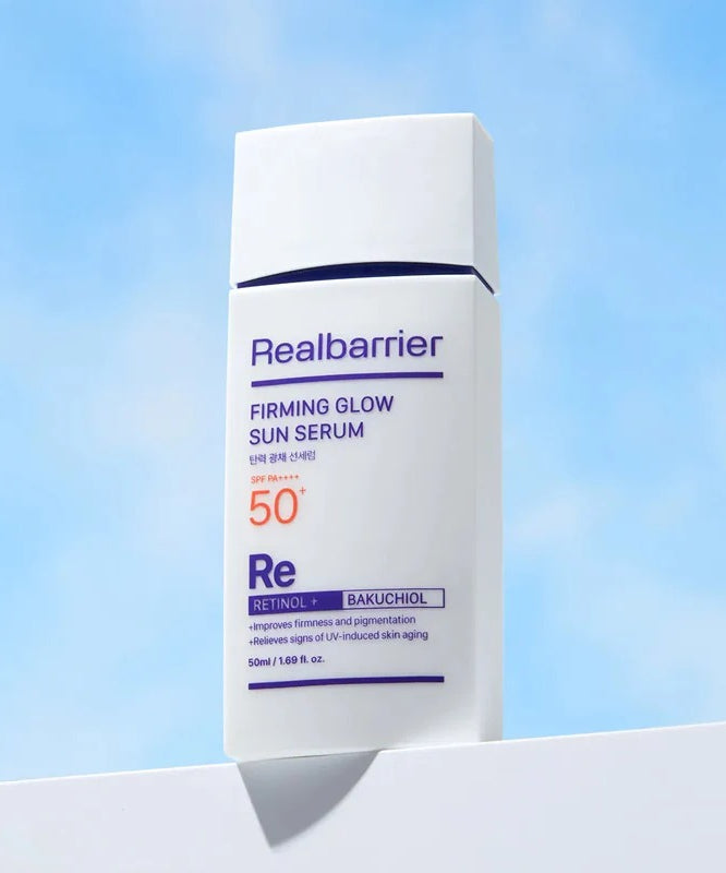 REAL BARRIER Elasticity & Radiance Sun Serum 50ml, Realbarrier, flacon crème solaire sur fond bleu ciel, lumière du jour.