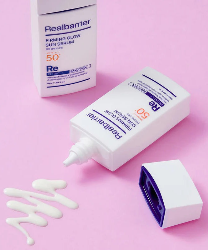 REAL BARRIER Elasticity & Radiance Sun Serum 50ml Realbarrier, tube et crème sur fond rose, texture blanche visible