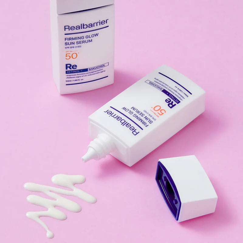 REAL BARRIER Elasticity & Radiance Sun Serum 50ml Realbarrier, tube et crème sur fond rose, texture blanche visible