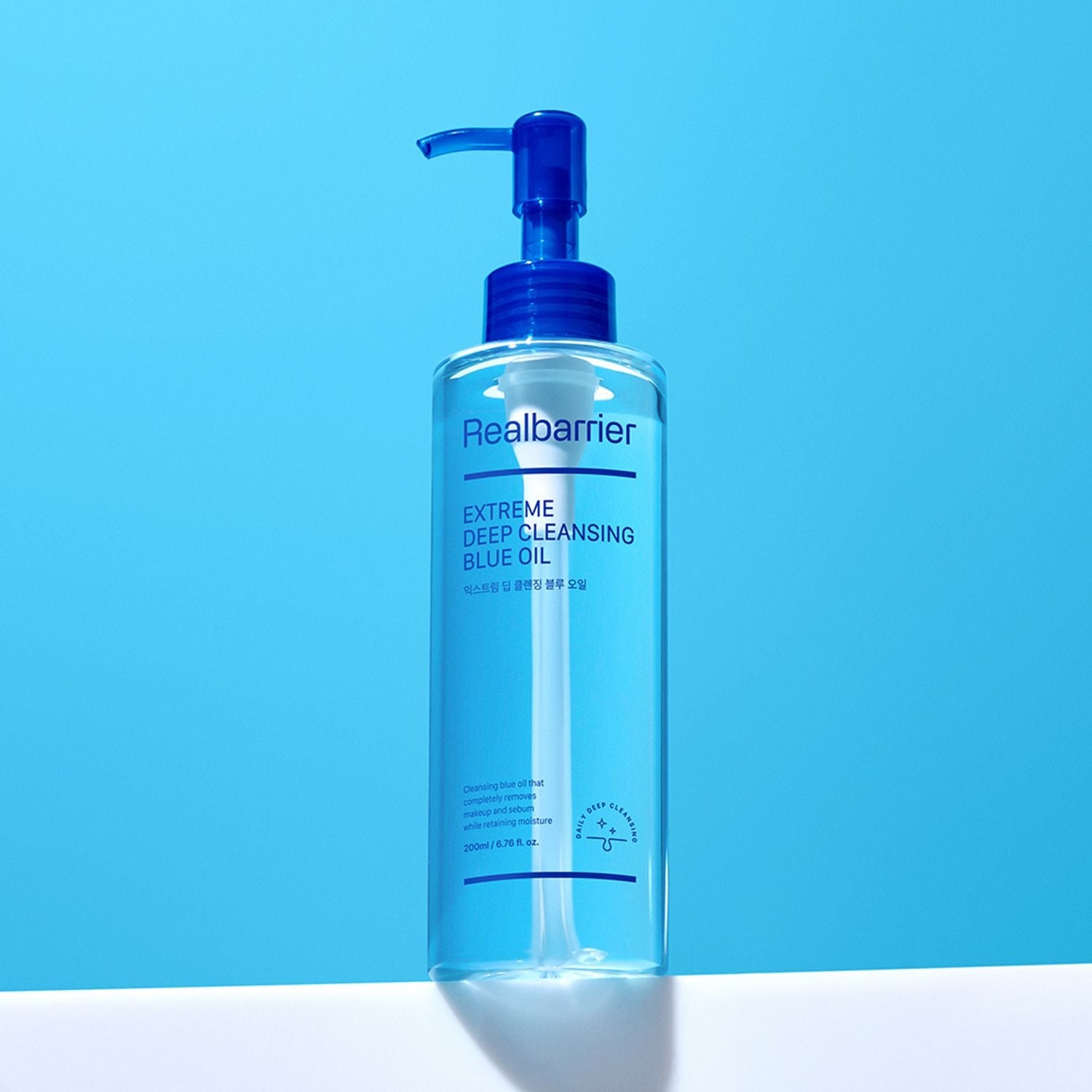 REAL BARRIER Extreme Deep Cleansing Blue Oil 200ml, flacon pompe Realbarrier, fond bleu, visuel produit en studio