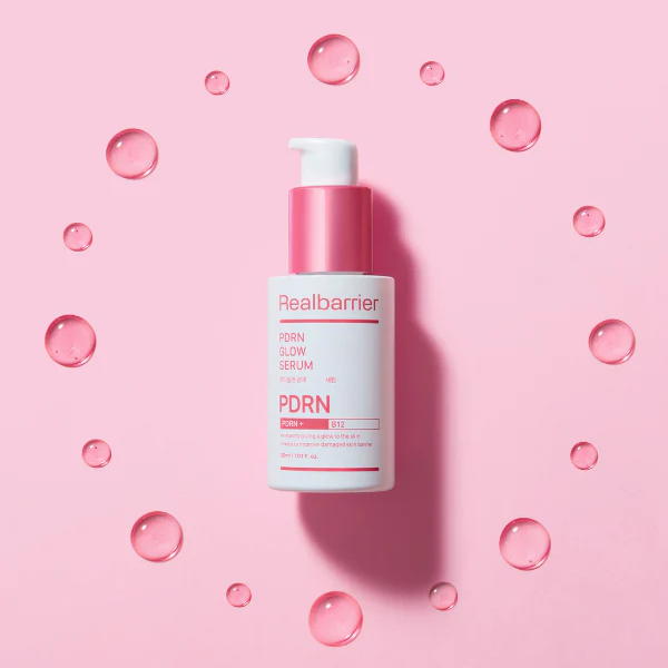 REAL BARRIER PDRN Radiance Repair Serum 30ml de Realbarrier sur fond rose avec bulles d’eau, photo produit cosmétique.