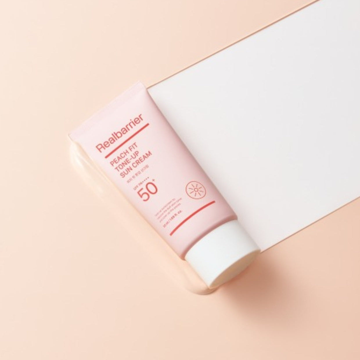 REAL BARRIER Peach Fit Tone-Up Sun Cream 50ml de la marque Real Barrier, tube crème solaire sur fond pastel beige.