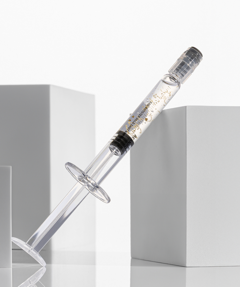 REANHU Exo Booster Gold Shot Ampoule 2 g X 7 ea, fiole ambrée dorée, flacon sur fond blanc, mise en scène produit