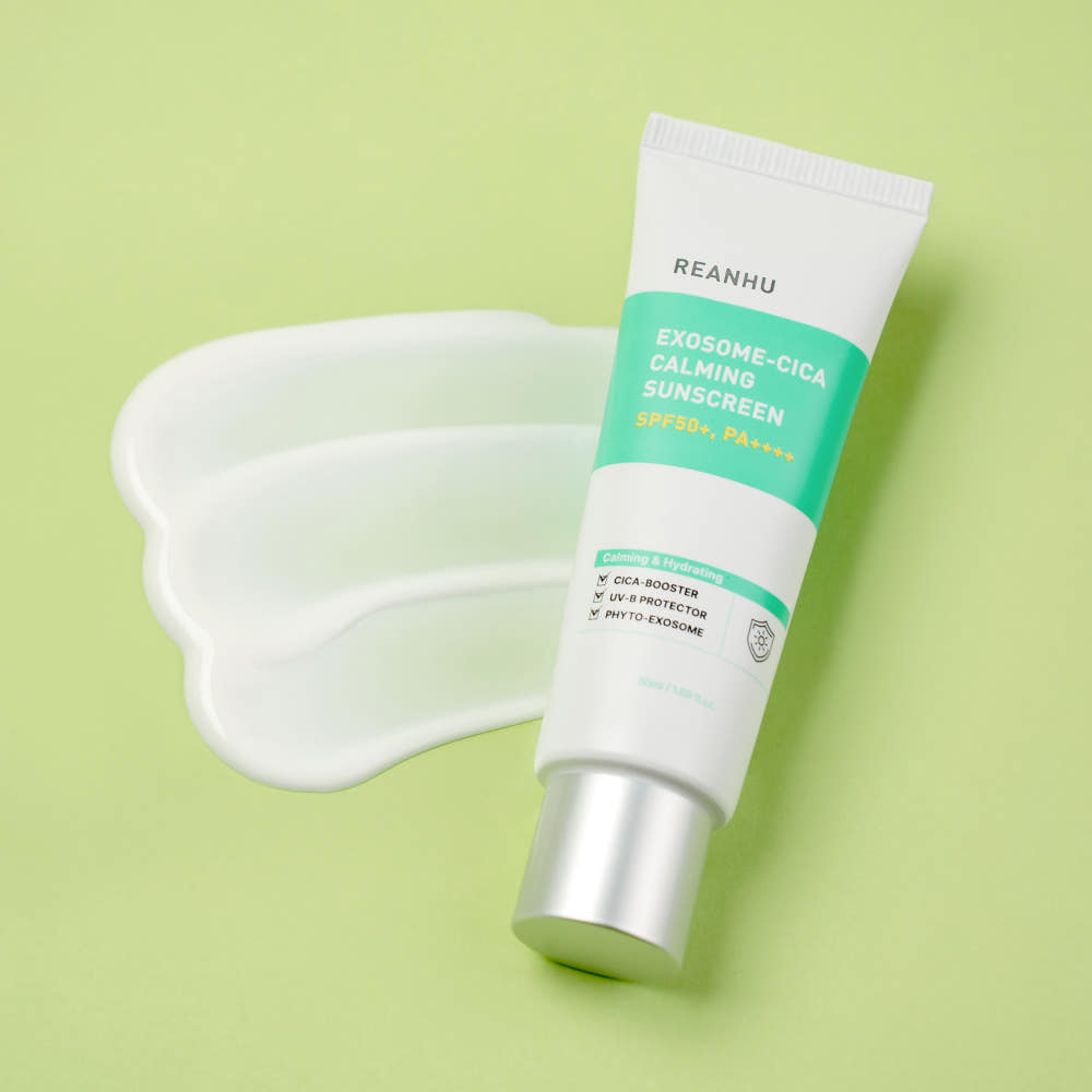 REANHU Exosome Cica Calming Sunscreen 50ml de la marque REANHU, tube sur fond vert pastel avec texture crème