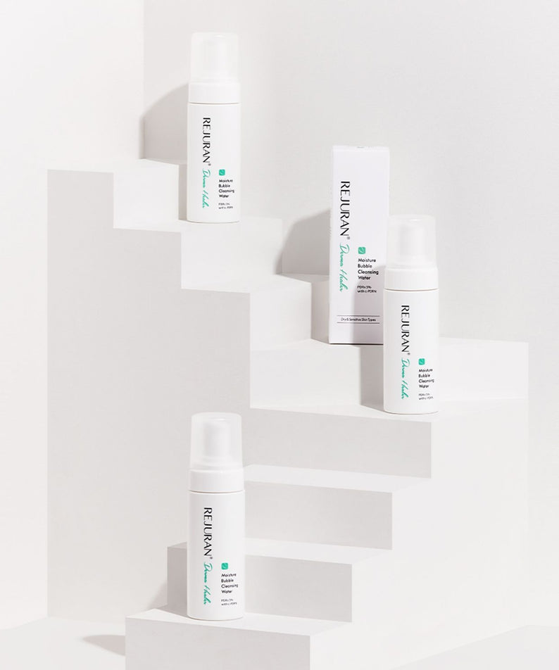 REJURAN Derma Healer Moisture Bubble Cleansing Water 150ml, flacon blanc sur cubes blancs, contexte visuel produit
