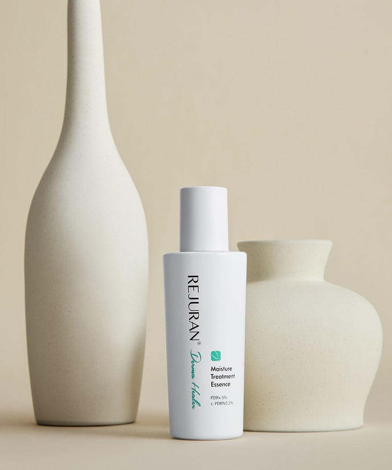 REJURAN Derma Healer Moisture Treatment Essence 70g : flacon blanc REJURAN sur décor minimal, vase et crème, vue produit