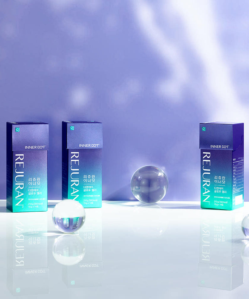 Trois boîtes de REJURAN Innerdo DNA Glow Jelly 1 box (14p) sur une surface blanche avec des sphères de verre, fond violet.