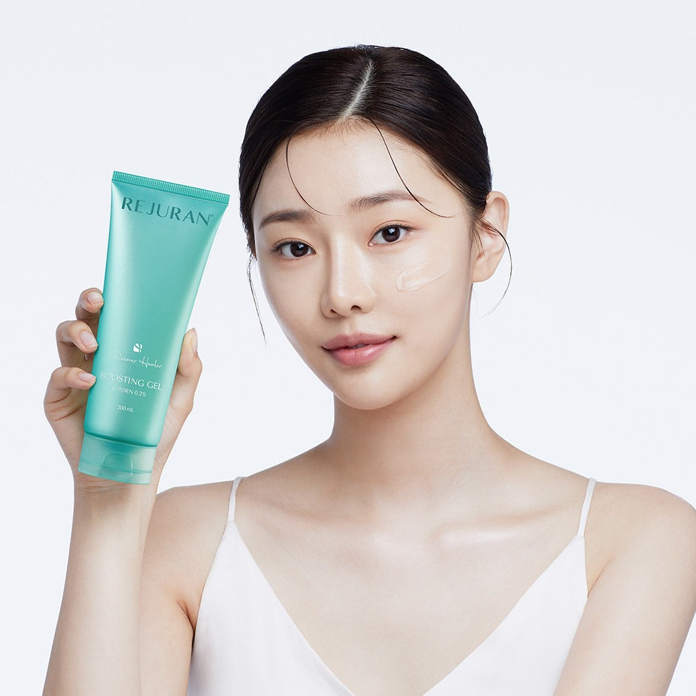 REJURAN Premium Beauty Device : femme tient un tube crème REJURAN, peau éclatante, fond clair, soin beauté.