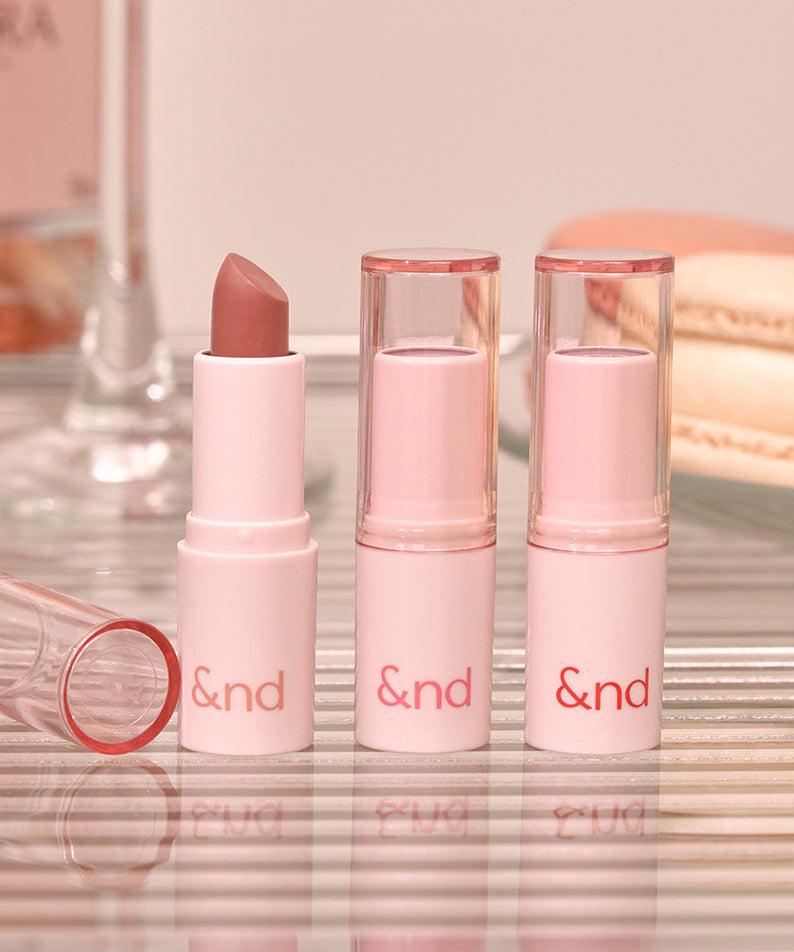 ROMAND  Glassy Bomb Balm, baume à lèvres rose & verres transparents sur fond maquillage doux, branding visible