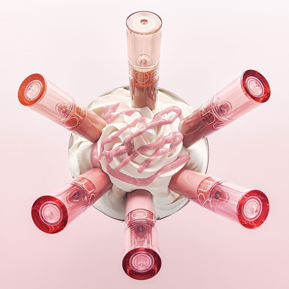 ROMAND Glasting Color Gloss #CreamNude de la marque Romand, flacons roses sur fond clair, visuel beauté maquillage.
