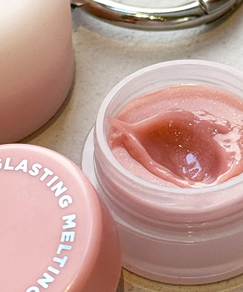 ROMAND Glasting Melting Pot de la marque ROMAND, pot ouvert avec texture rose, contexte visuel soin cosmétique