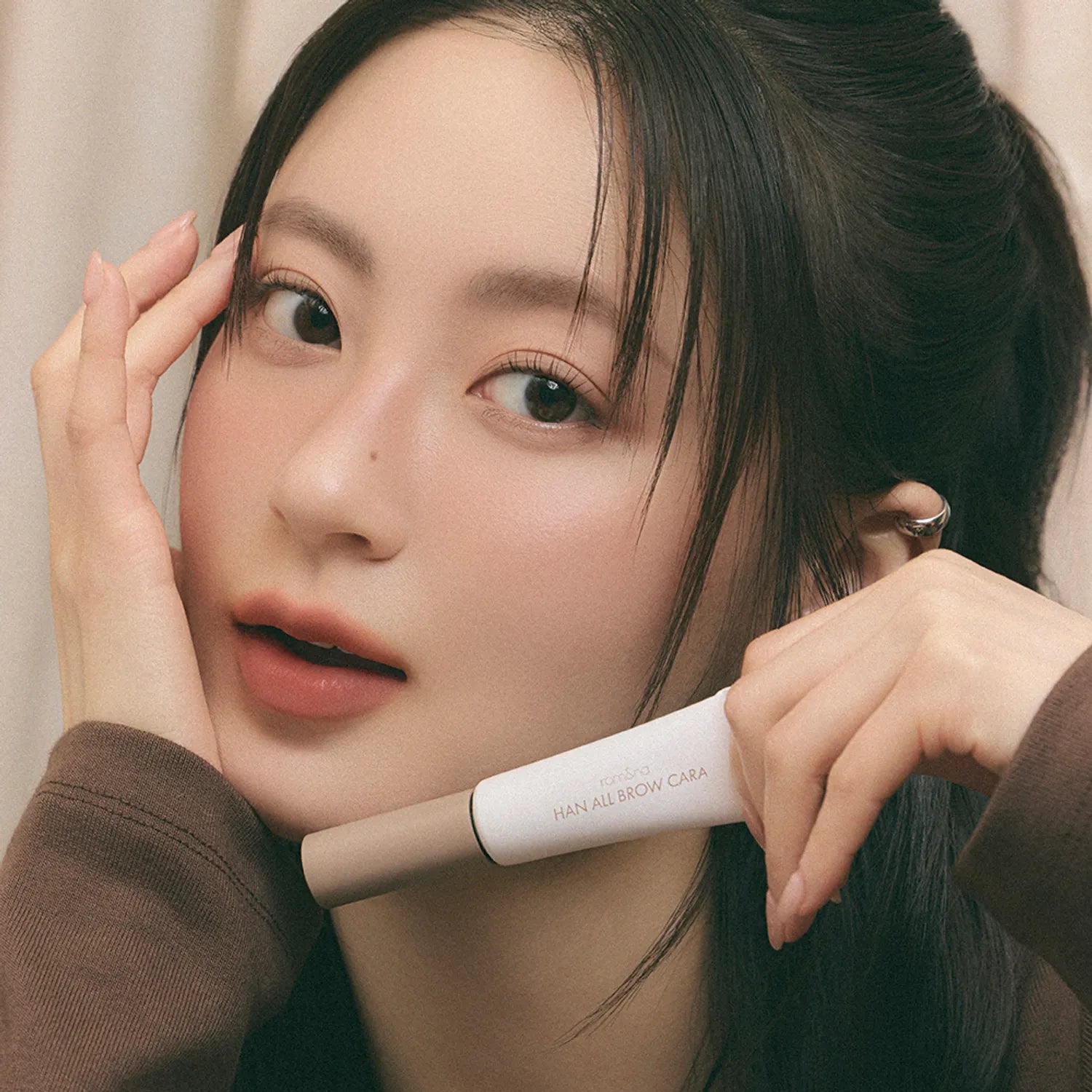 ROMAND  Hanol Brow Cara Single Item, tube maquillage sourcils sur fond beige, gros plan visage maquillé