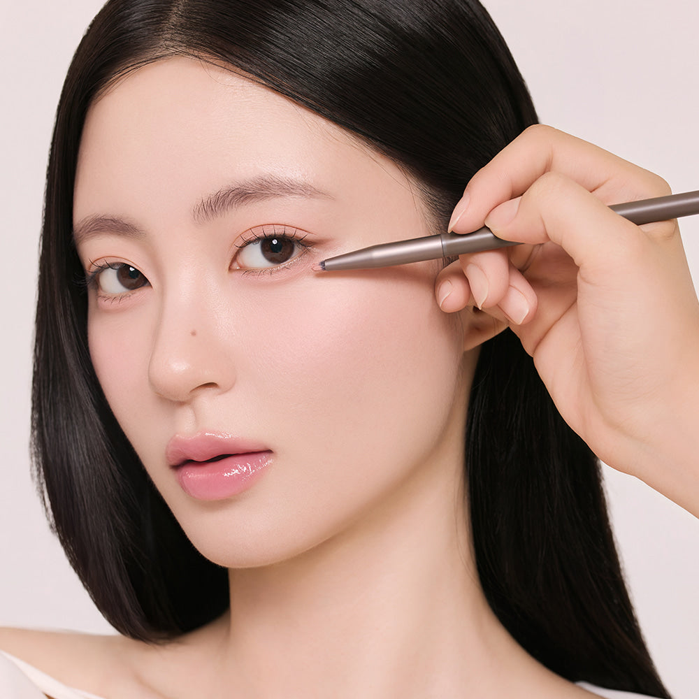ROMAND Hanol iPod Liner, maquillage sur modèle en gros plan, main applique l’eye-liner, fond clair