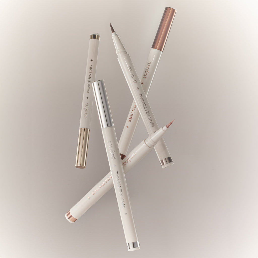 ROMAND  Twinkle Pen Liner, stylos eyeliner pailletés sur fond clair, marque ROMAND, ensemble de produits maquillage.