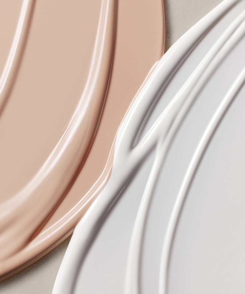 Texture de ROMAND white me tone up sun cushion montrant les tons crème et blanc pour un soin solaire et maquillage lumineux.