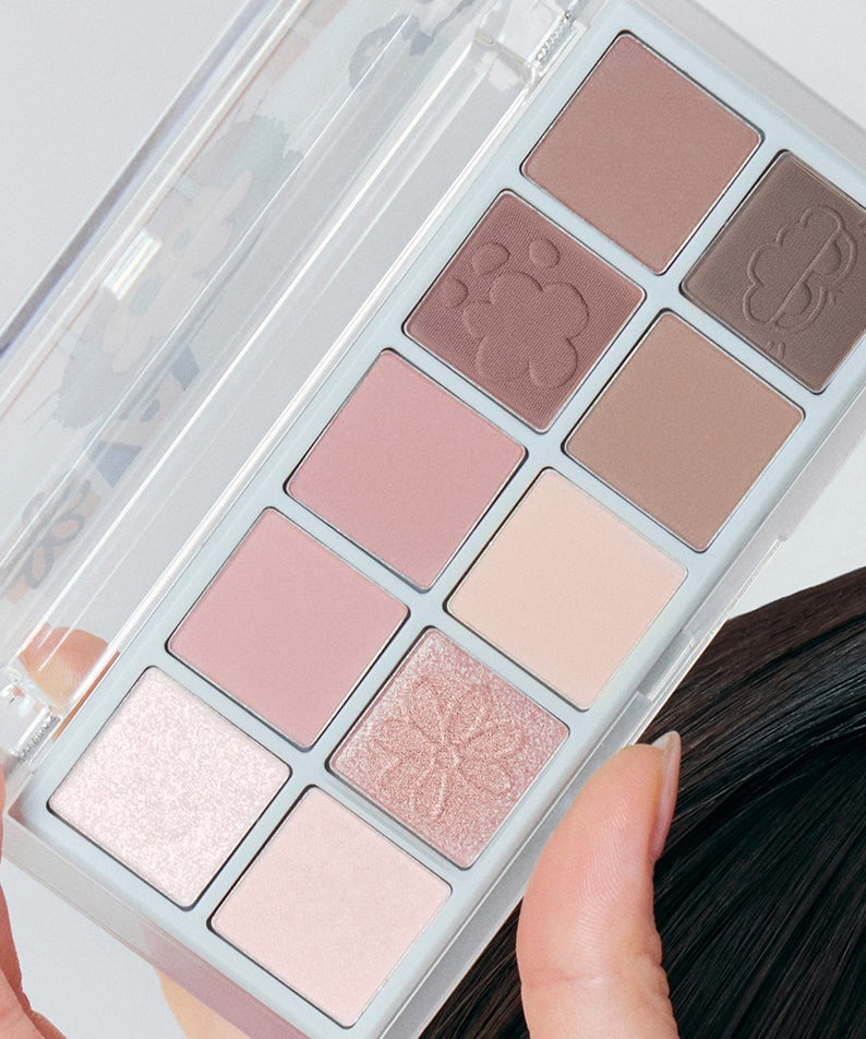 ROMAND x Joanne Friends Better Than Palette, maquillage palette de fards nude, boîtier transparent, mains et pinceau, vue rapprochée
