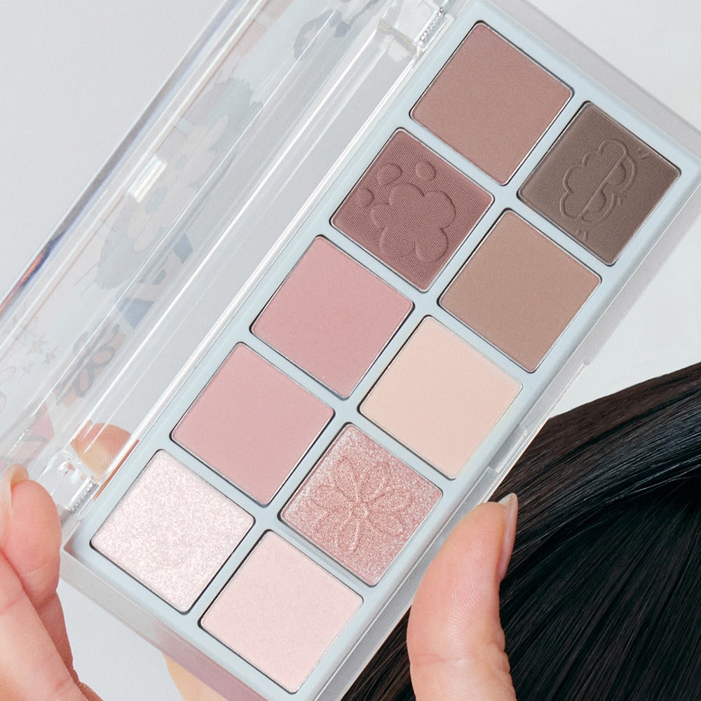 ROMAND x Joanne Friends Better Than Palette, maquillage palette de fards nude, boîtier transparent, mains et pinceau, vue rapprochée