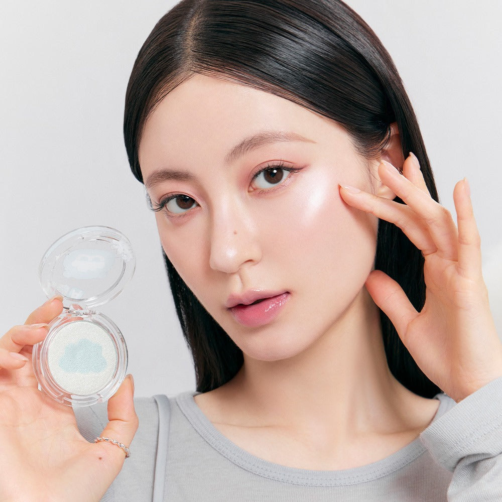 ROMAND x Joanne Friends Dual Jelly Highlighter : produit de la marque ROMAND sur peau maquillée, duo gelée lumineuse, main tenant le boîtier.
