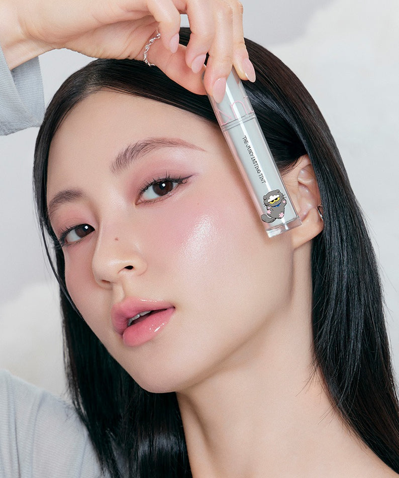 ROMAND x Joanne Friends The Juicy Lasting Tint, la marque sur un tube maquillage, femme aux lèvres rosées, fond clair