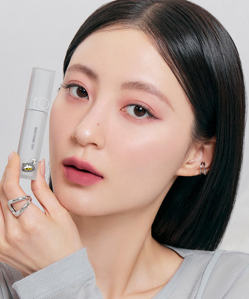 Femme tenant ROMAND x Joanne Friends Blur Fudge Tint, maquillage élégant, innovations cosmétiques coréennes.