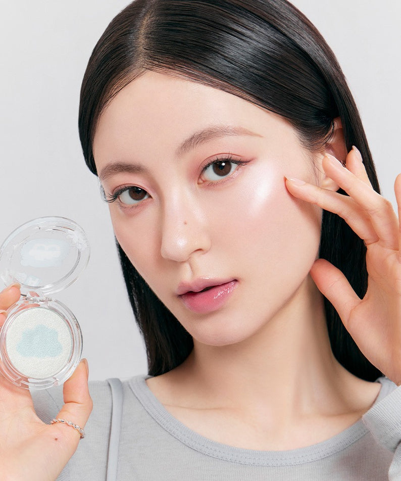 Femme utilisant le ROMAND x Joanne Friends Dual Jelly Highlighter sur sa joue, produit de beauté pour un éclat lumineux.