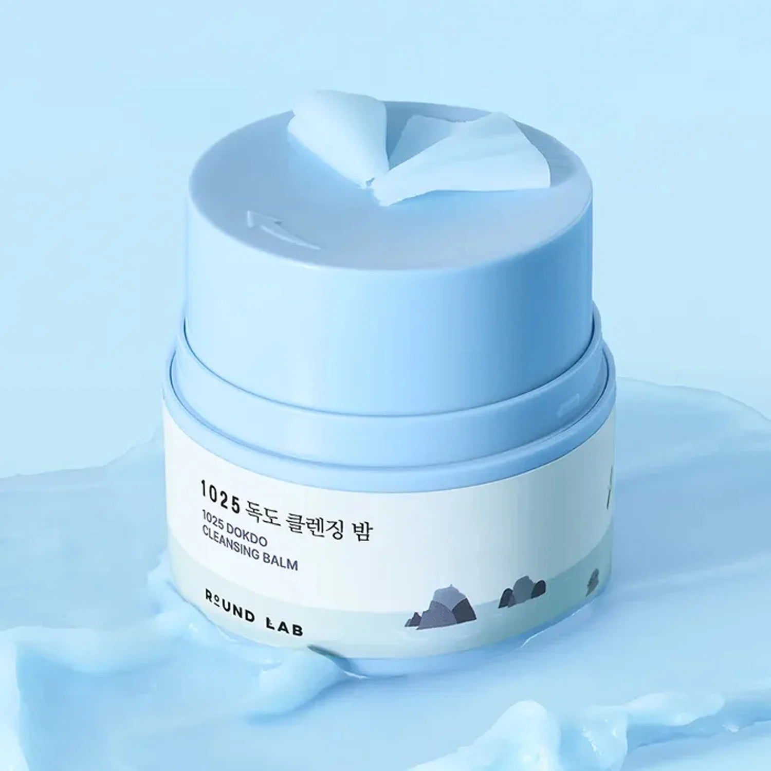 ROUND LAB 1025 Dokdo Cleansing Balm 50ml de ROUND LAB sur fond bleu, baume nettoyant en contexte spa.