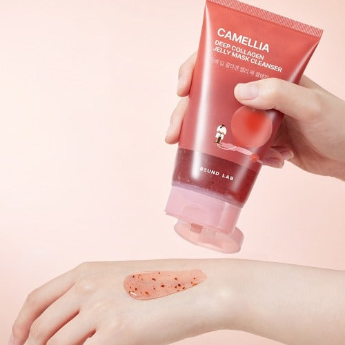 ROUND LAB Camellia Deep Collagen Jelly Pack Cleanser 150ml, tube cosmétique en main, peau enduite, fond clair.
