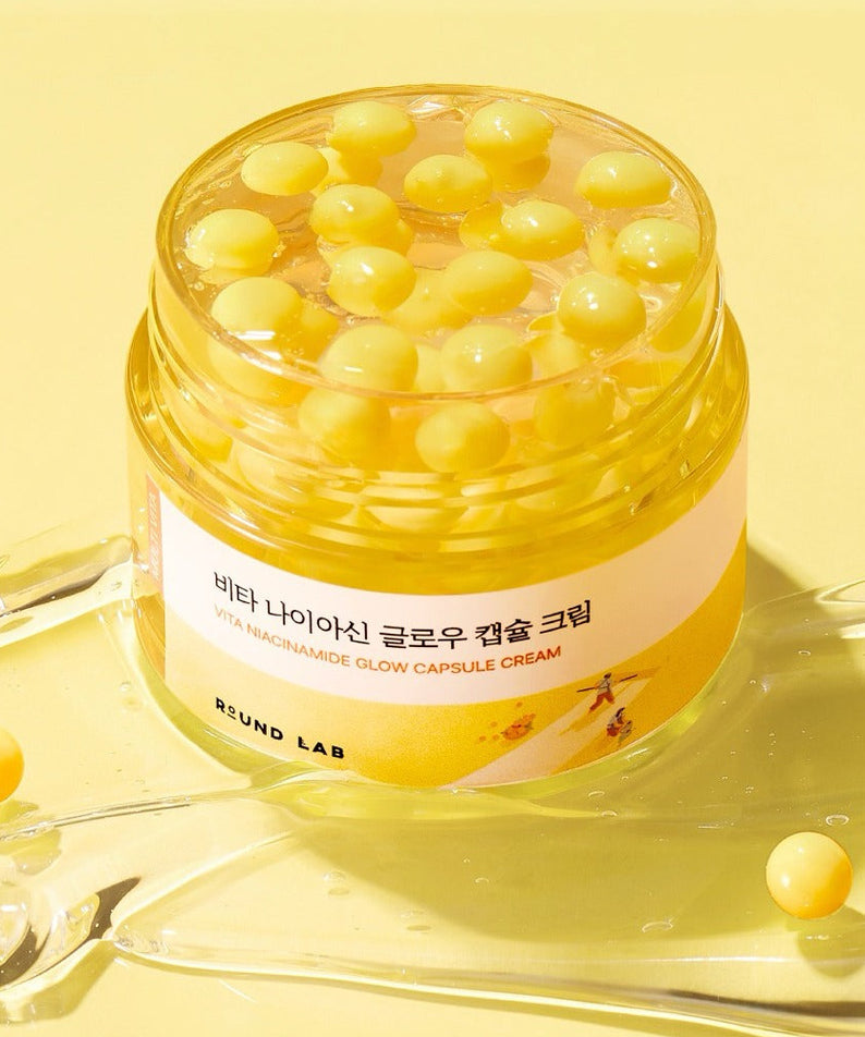 ROUND LAB  Vita Niacin Glow Capsule Cream 50ml, pot crème jaune avec capsules, sur fond lumineux jaune, marque présentée