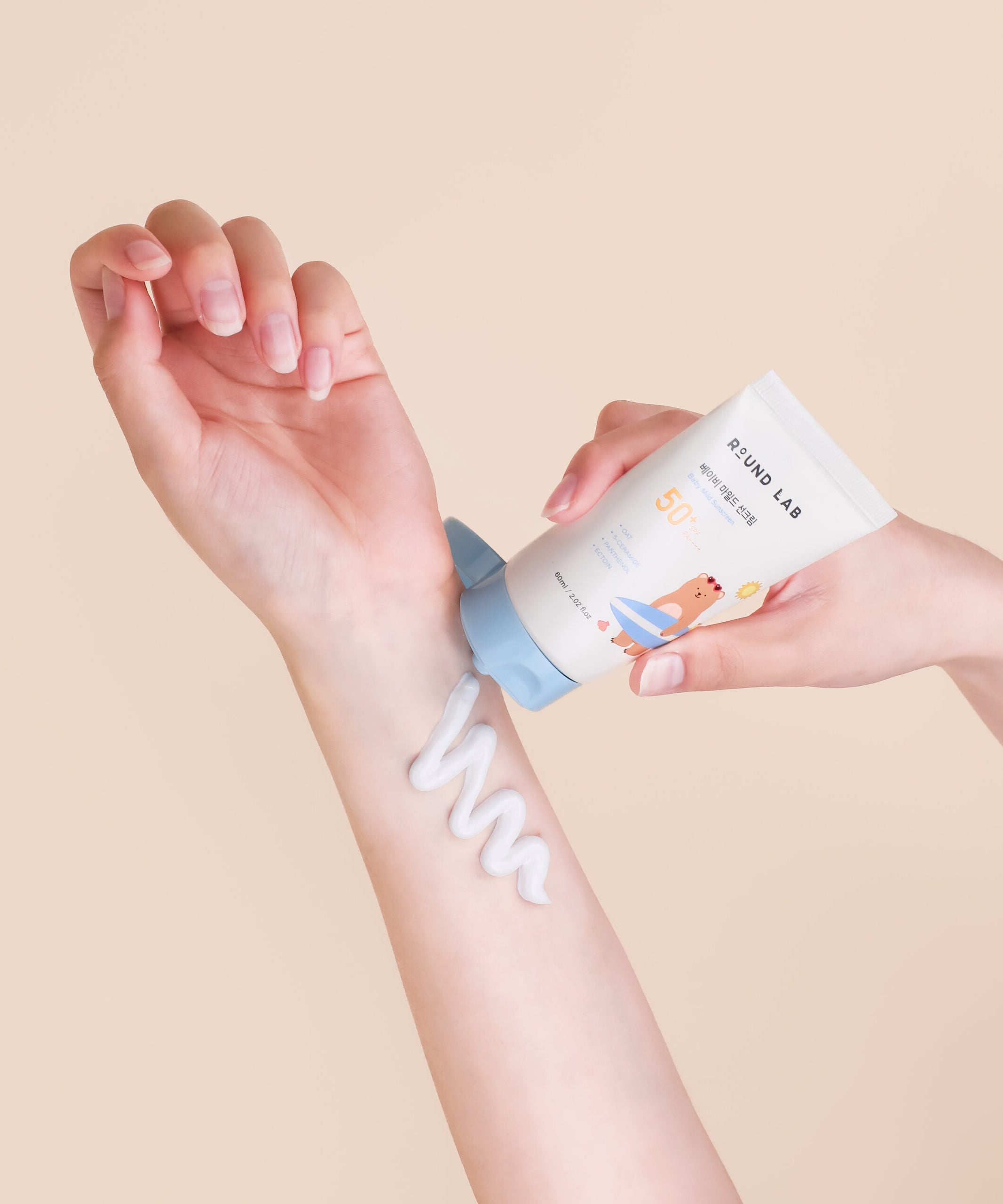 Application de ROUND LAB Baby Mild Sun Cream 60ml sur le bras d'un adulte, protection solaire douce pour les peaux sensibles.