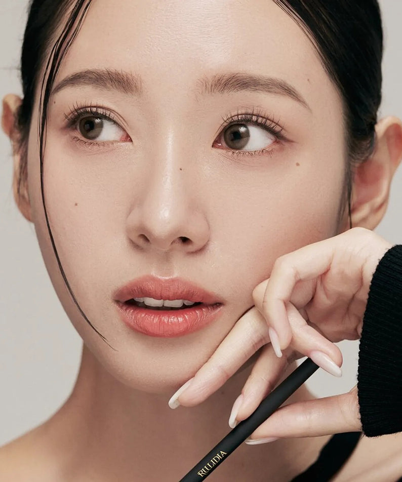 RULIDIA Easy Detail Brow, maquillage sourcils de la marque RULIDIA : main ajuste l’outil sur le visage, fond clair