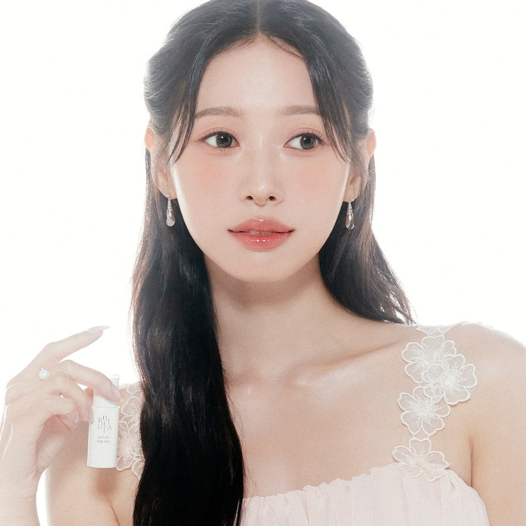 RULIDIA Ritual Dew Tint, marque RULIDIA, maquillage rosé sur femme, flacon tenu en main, fond clair