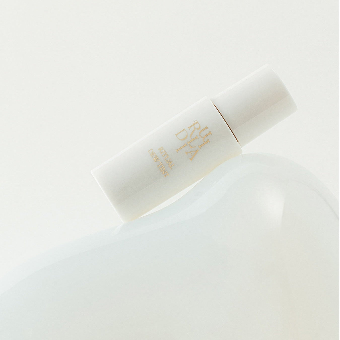 RULIDIA Ritual Dew Tint de la marque RULIDIA, flacon nude sur fond blanc minimaliste, rendu lumineux en maquillage