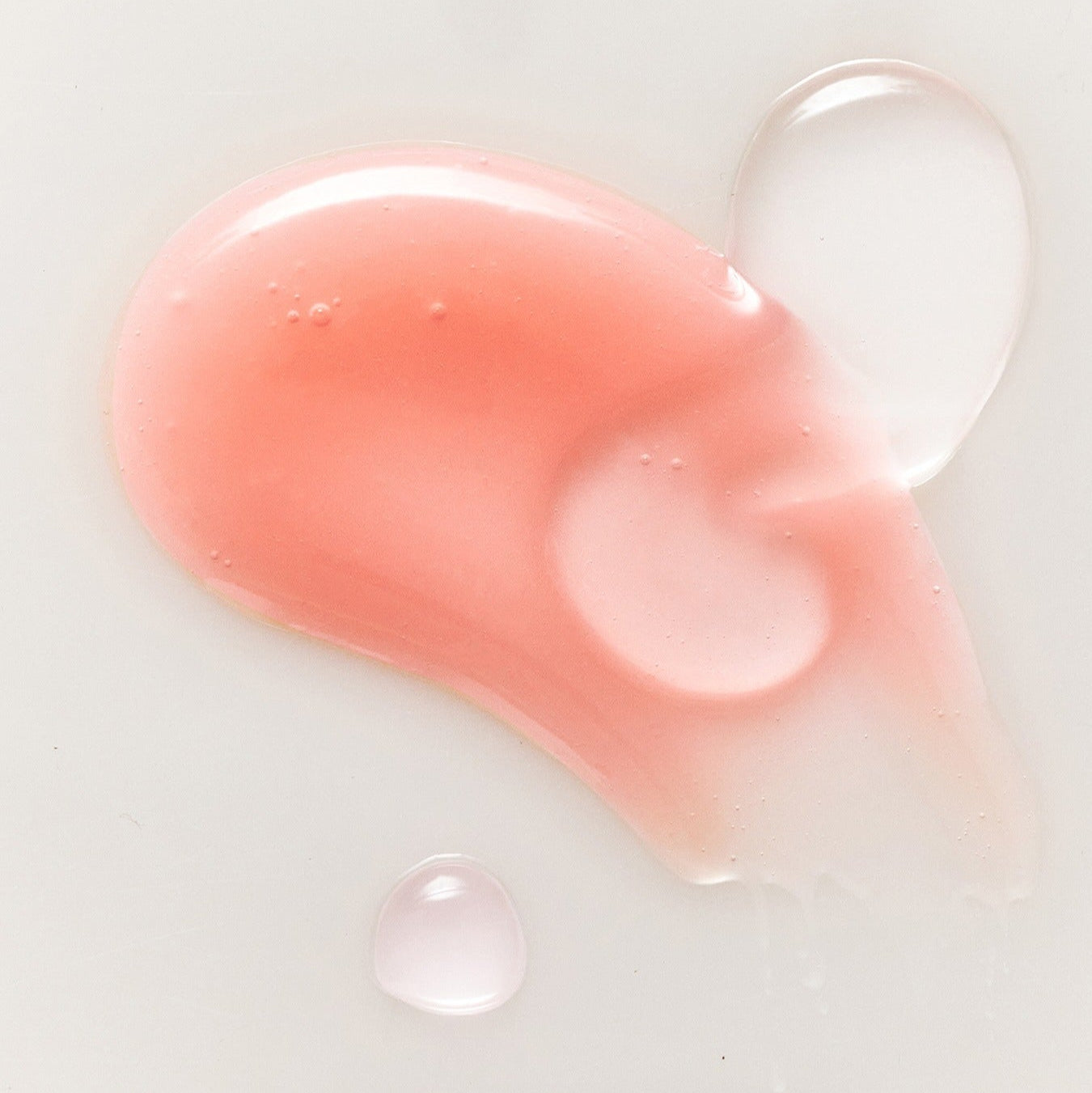 RULIDIA Shining Moment Caring Lip Balm 8g : baume luisant à texture rose, gouttes et produit en gros plan sur fond clair.