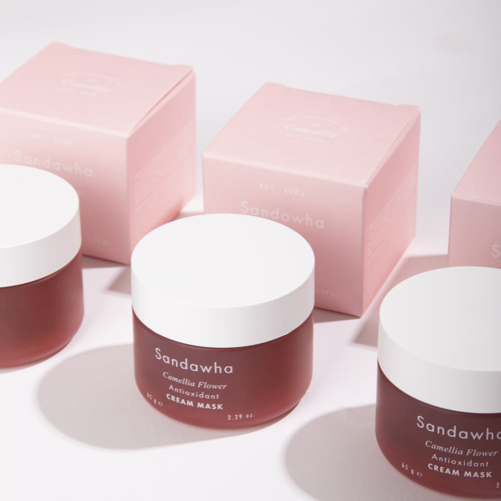 SANDAWHA Camellia Flower Cream Mask 65g de Sandawha, pots roses sur fond clair, en pack cosmétique.
