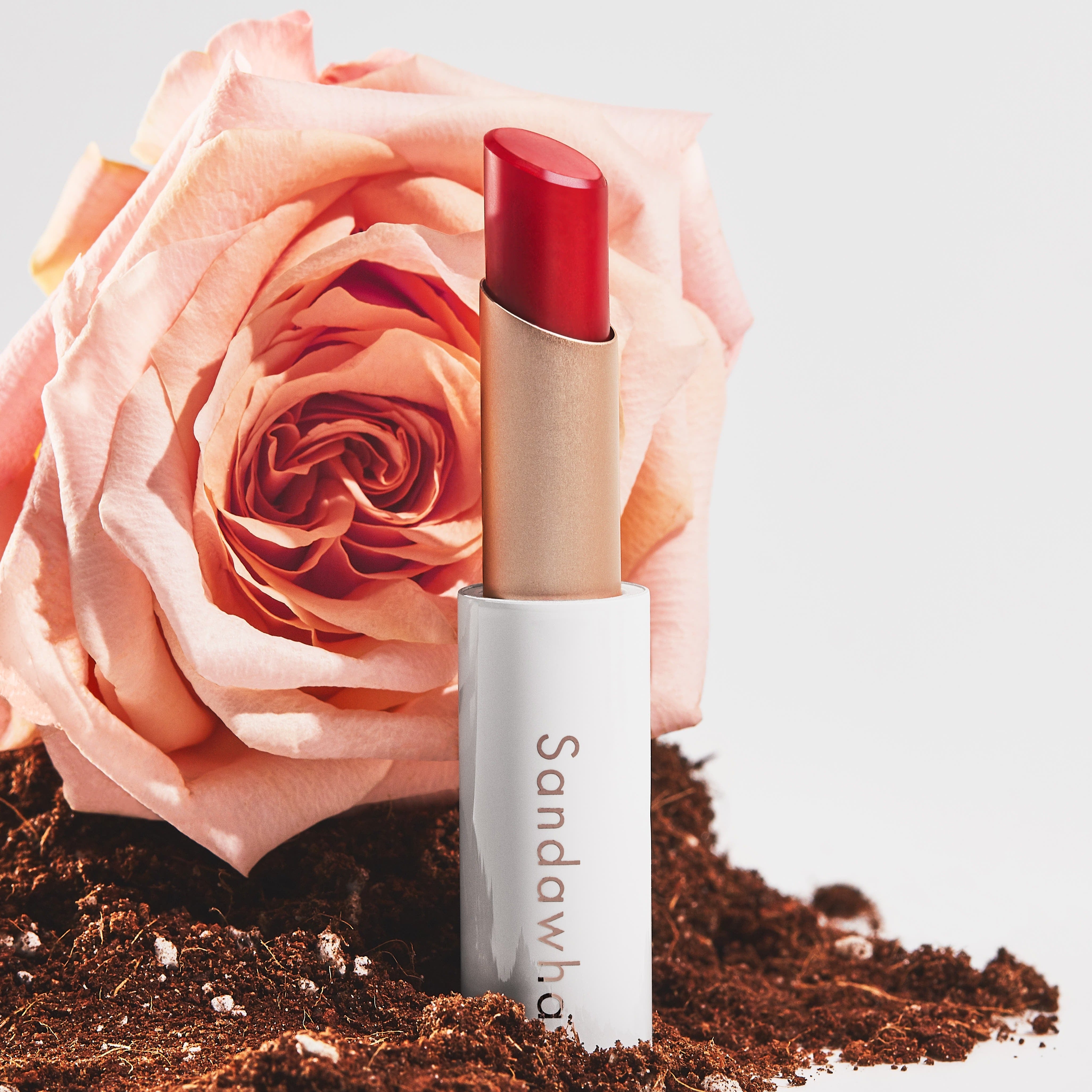 SANDAWHA Floral Halo Lip Glow : rouge à lèvres près d'une fleur rose et poudre sur fond clair, marque SANDAWHA