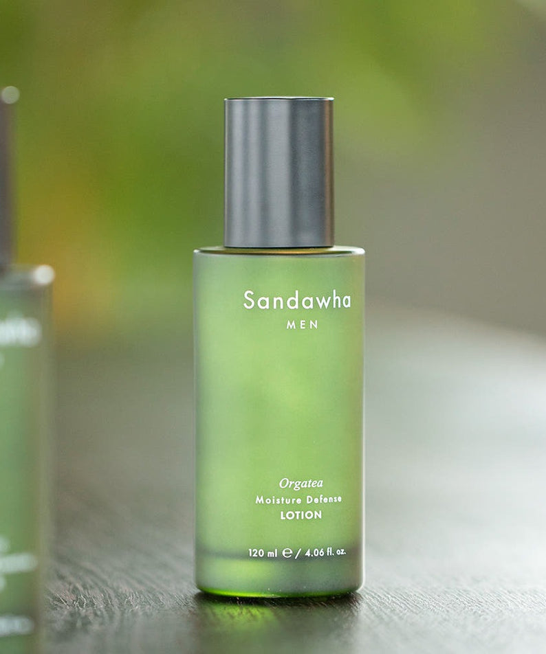 SANDAWHA For Men Orgatea Moiture Defense Lotion 120ml, flacon vert sur table, arrière-plan flou, photo produit en studio.