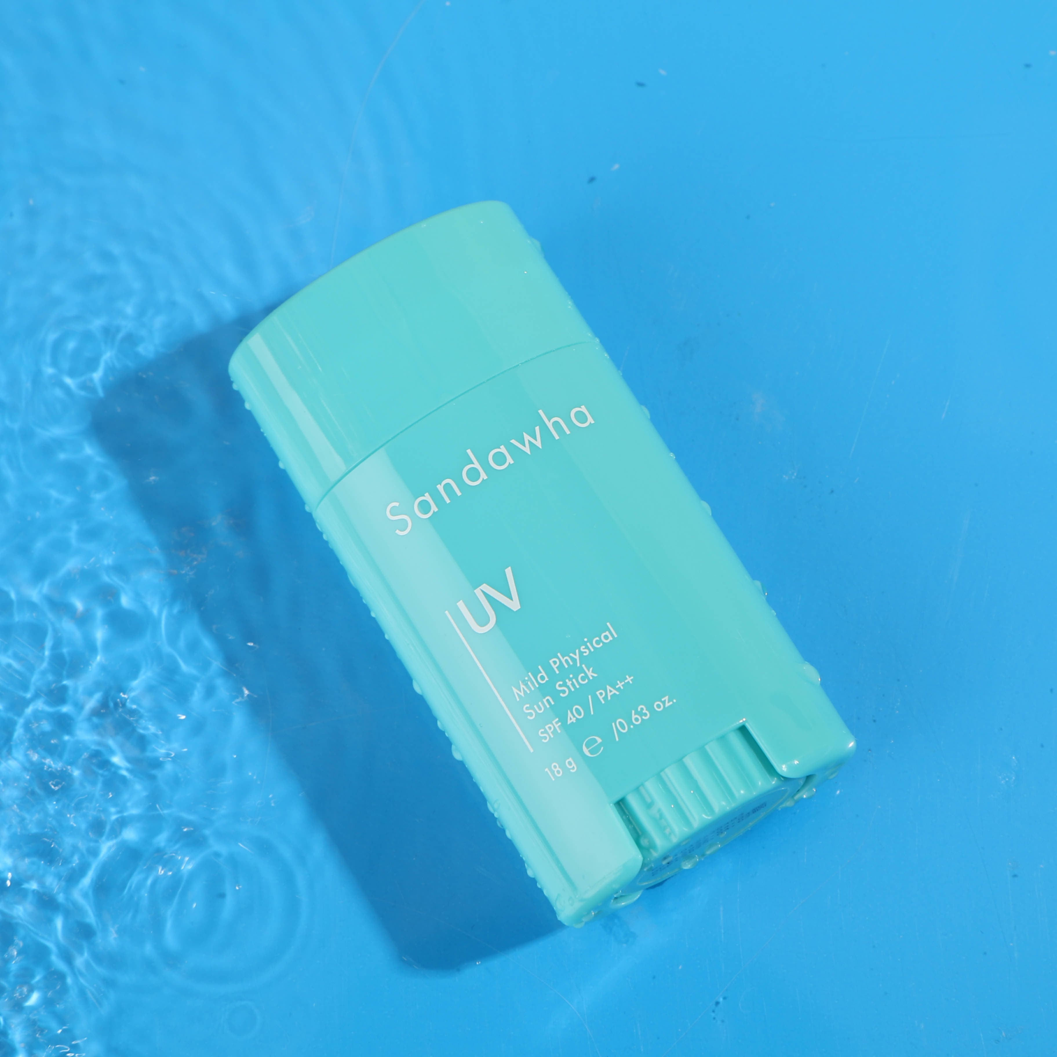 SANDAWHA Mild Mineral Sunscreen Stick SPF40 PA++ 18g, sur fond bleu évoquant des eaux, bâton solaire de la marque.